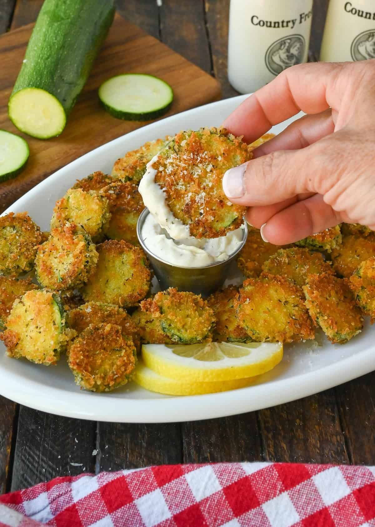 A zucchini crisp being dipped into ranch.