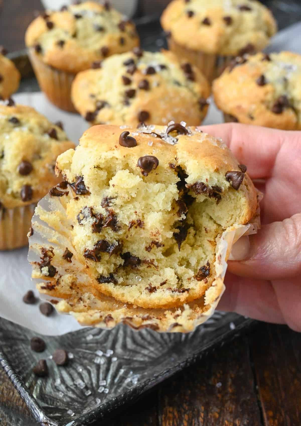 A bite out of a chocolate chip muffin.