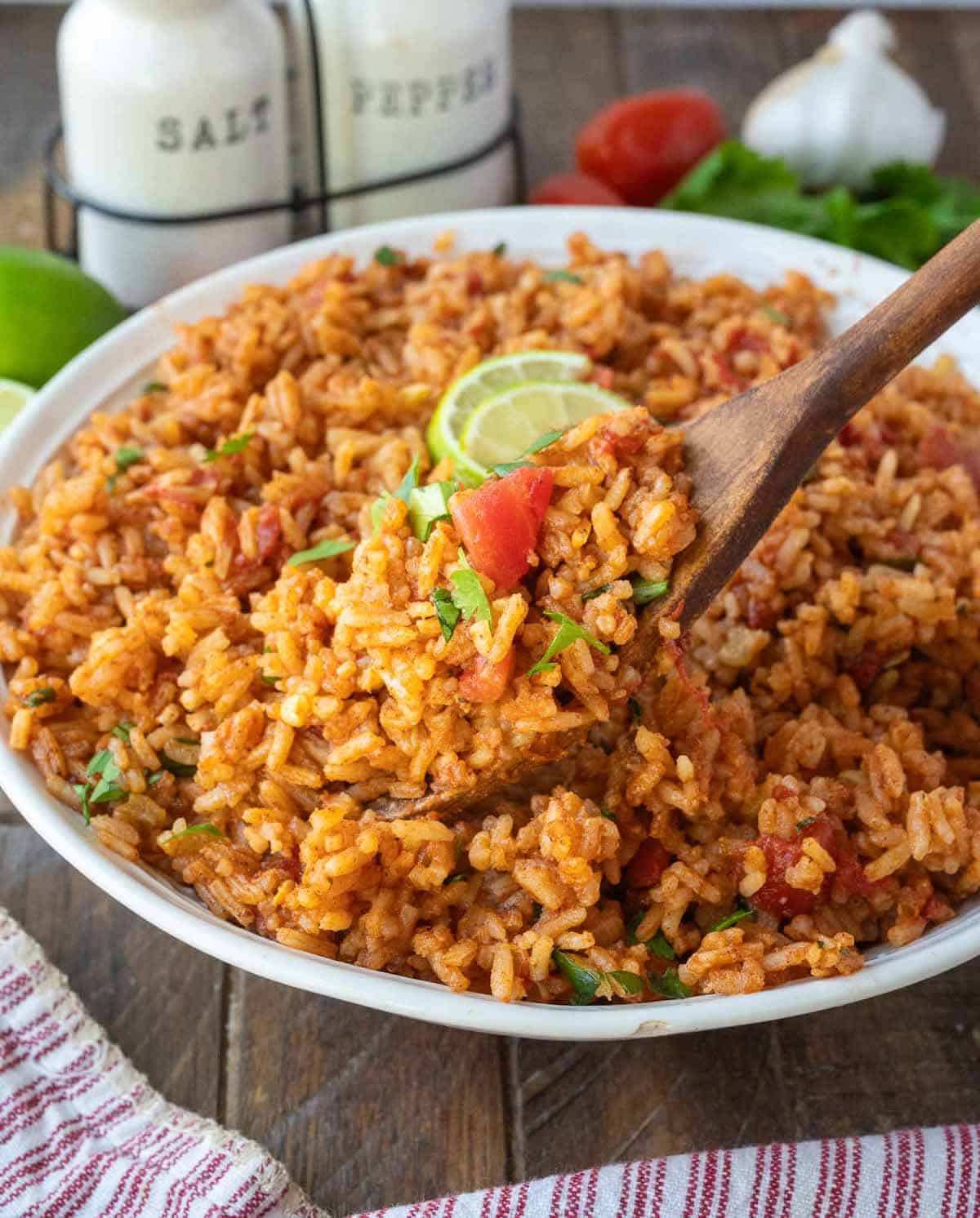 A wooden spoon scooping up some mexican rice.
