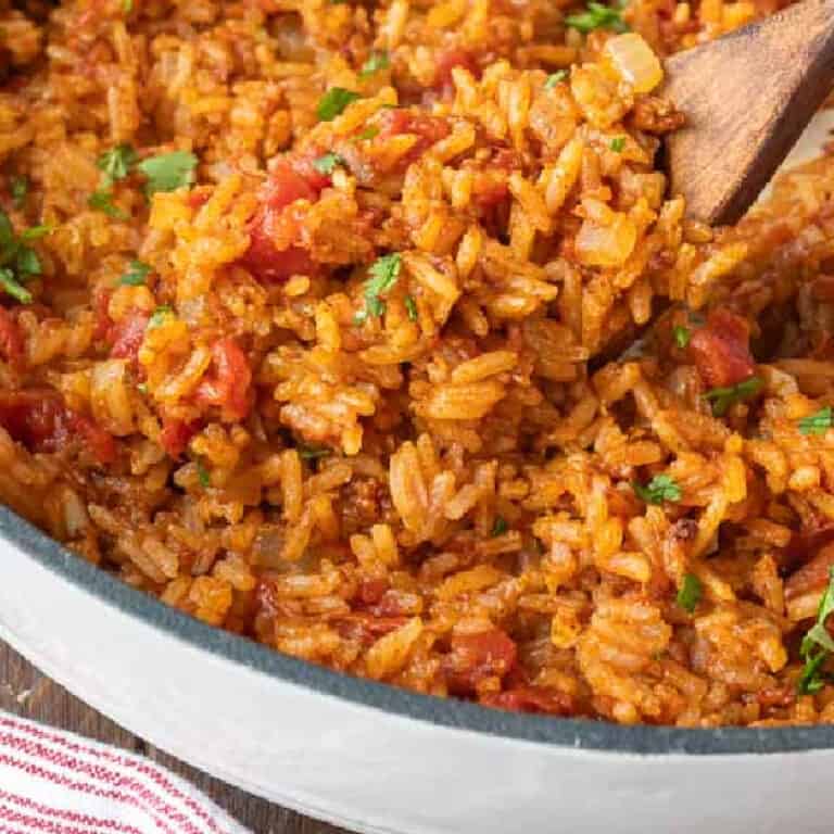 A wooden spoon scooping up some mexican rice.