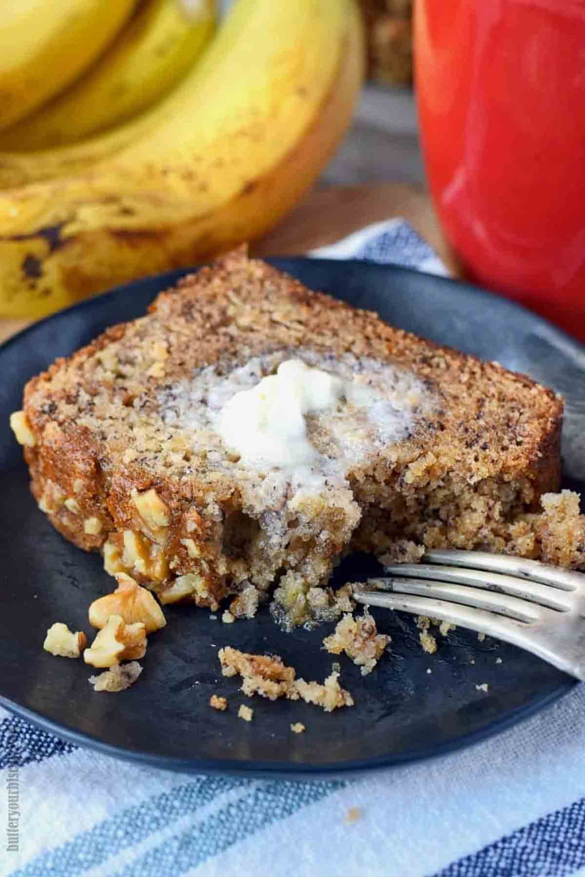 A slice of banana bread on a plate with a fork.