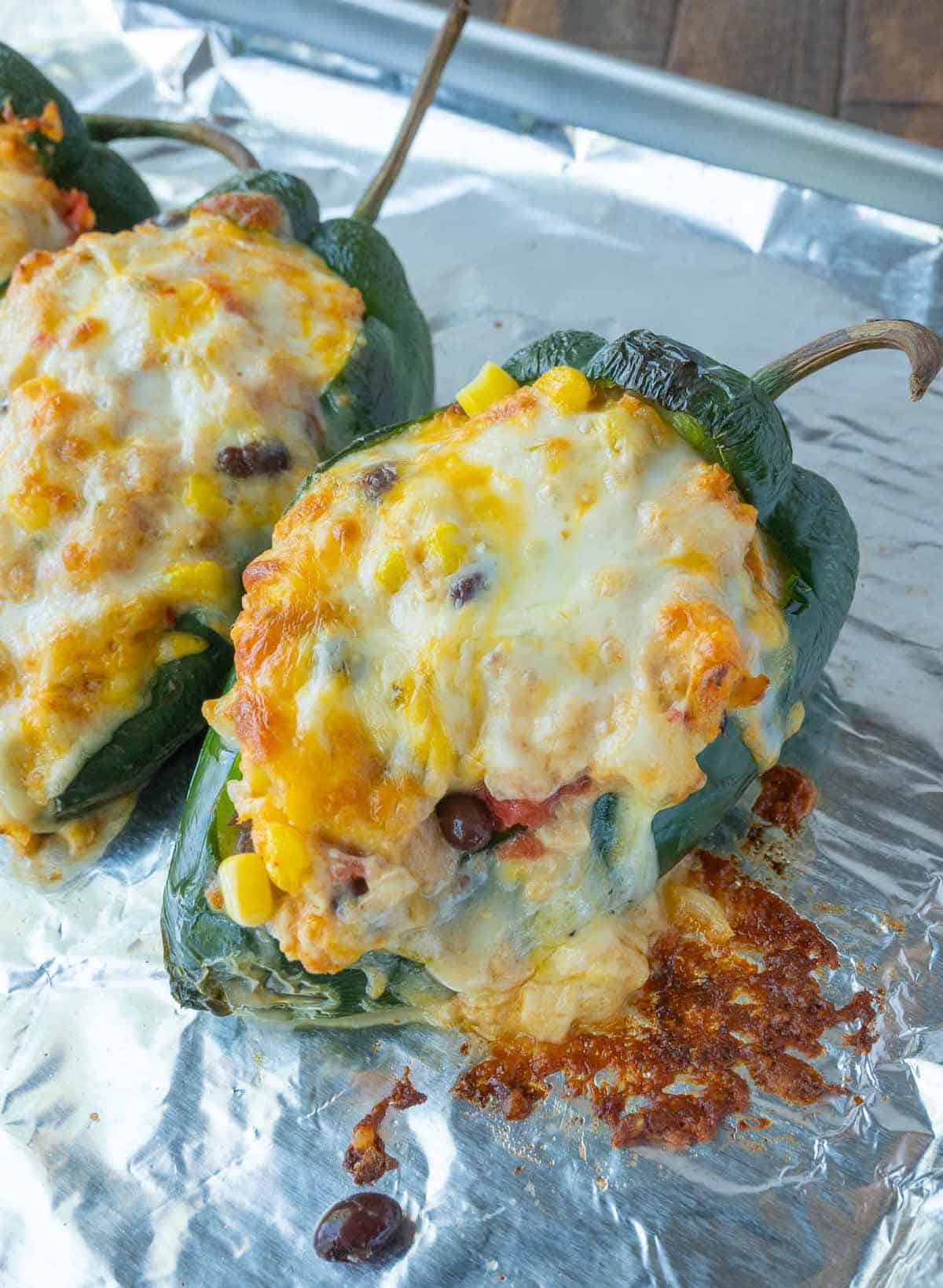Stuffed poblano peppers on a baking sheet.