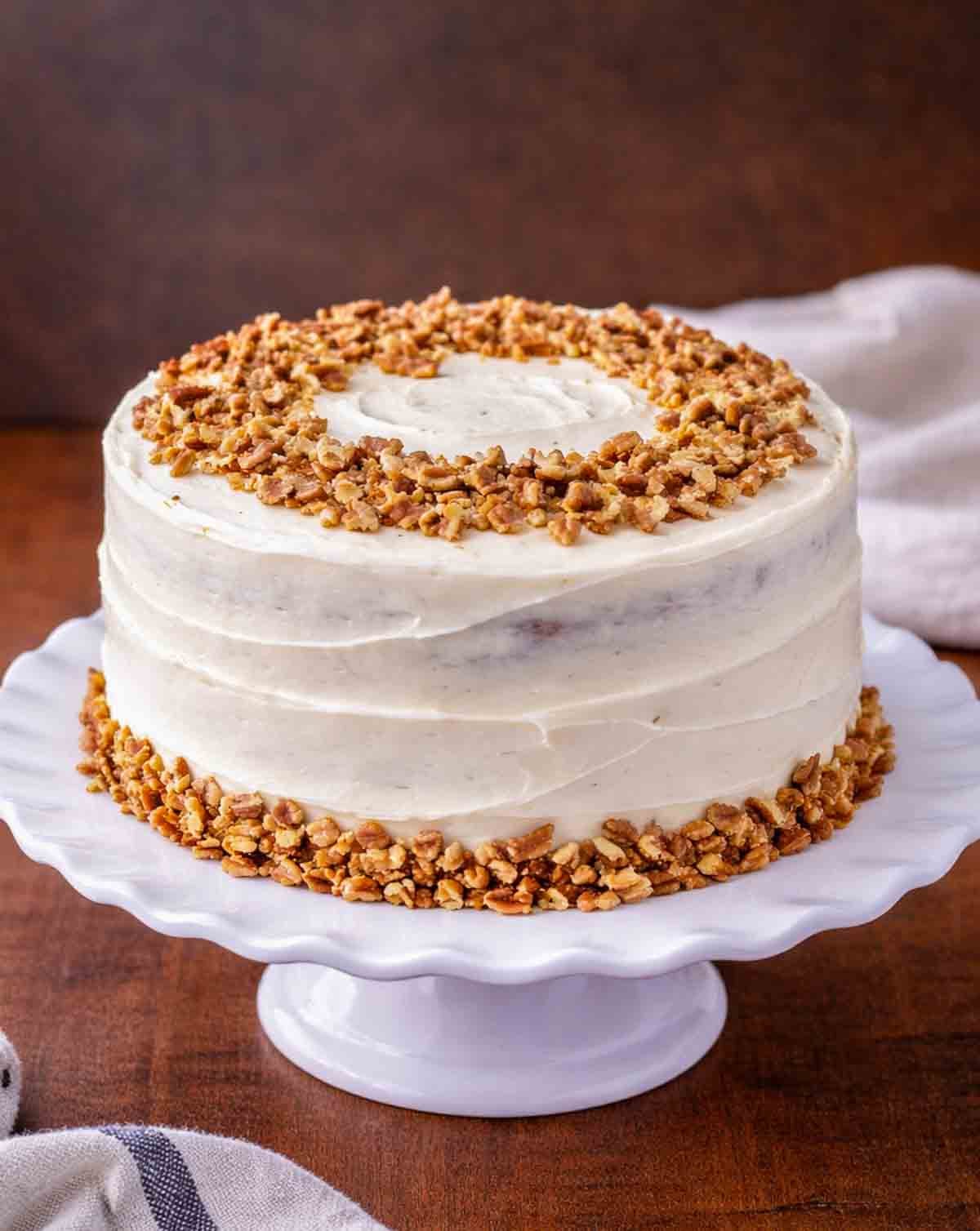 A layered carrot cake on a platter.
