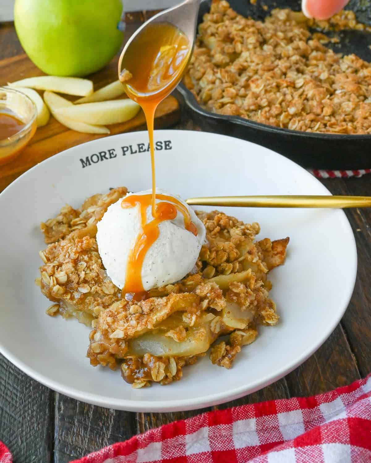 Apple crisp on a white plate with ice cream.