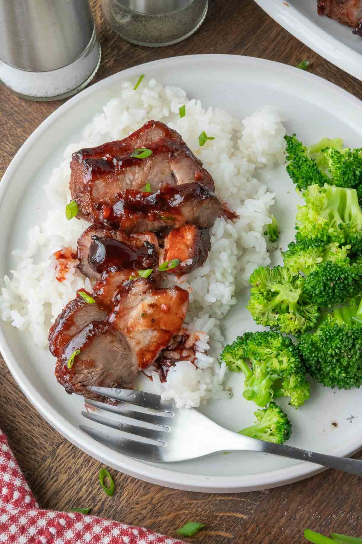 Chinese bbq pork on some white rive and broccoli.