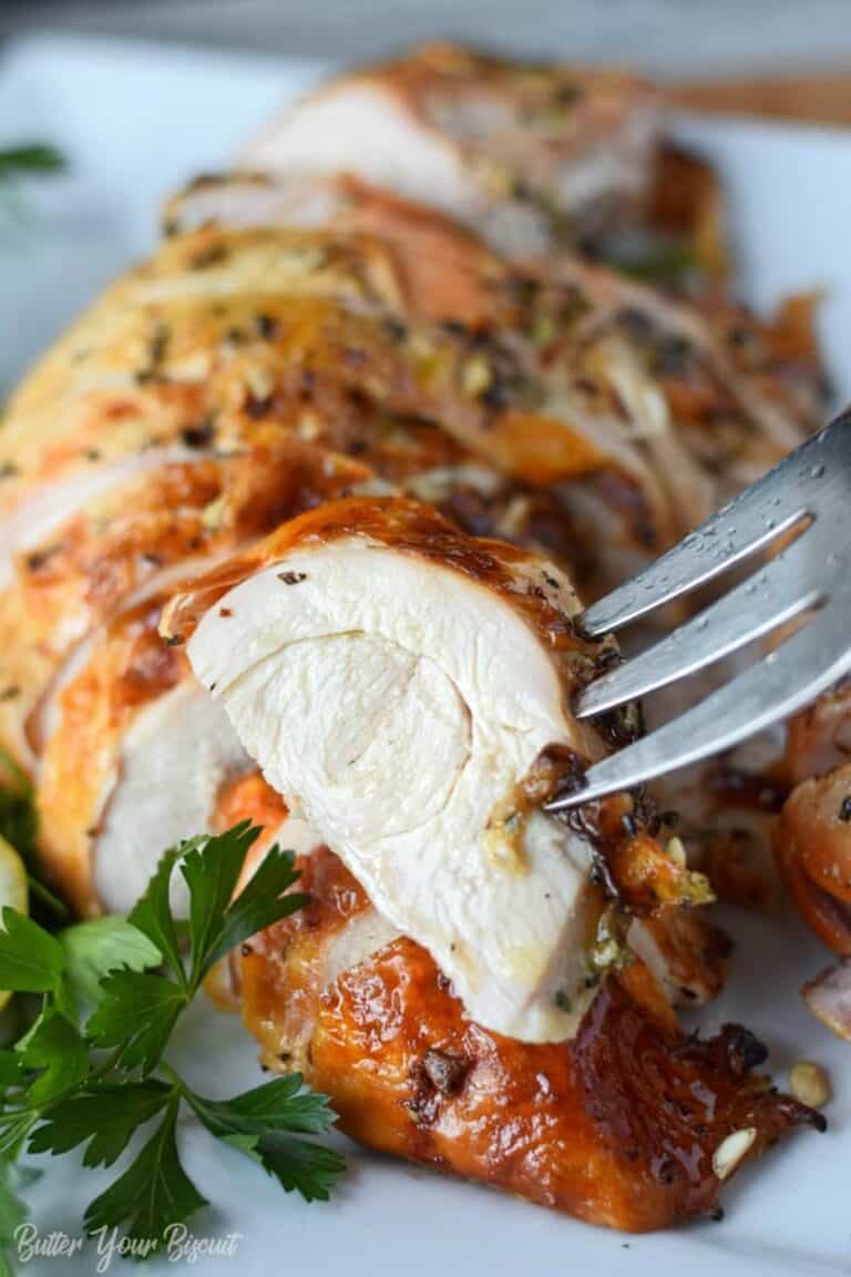 A serving fork picking up a slice of brined turkey breast.