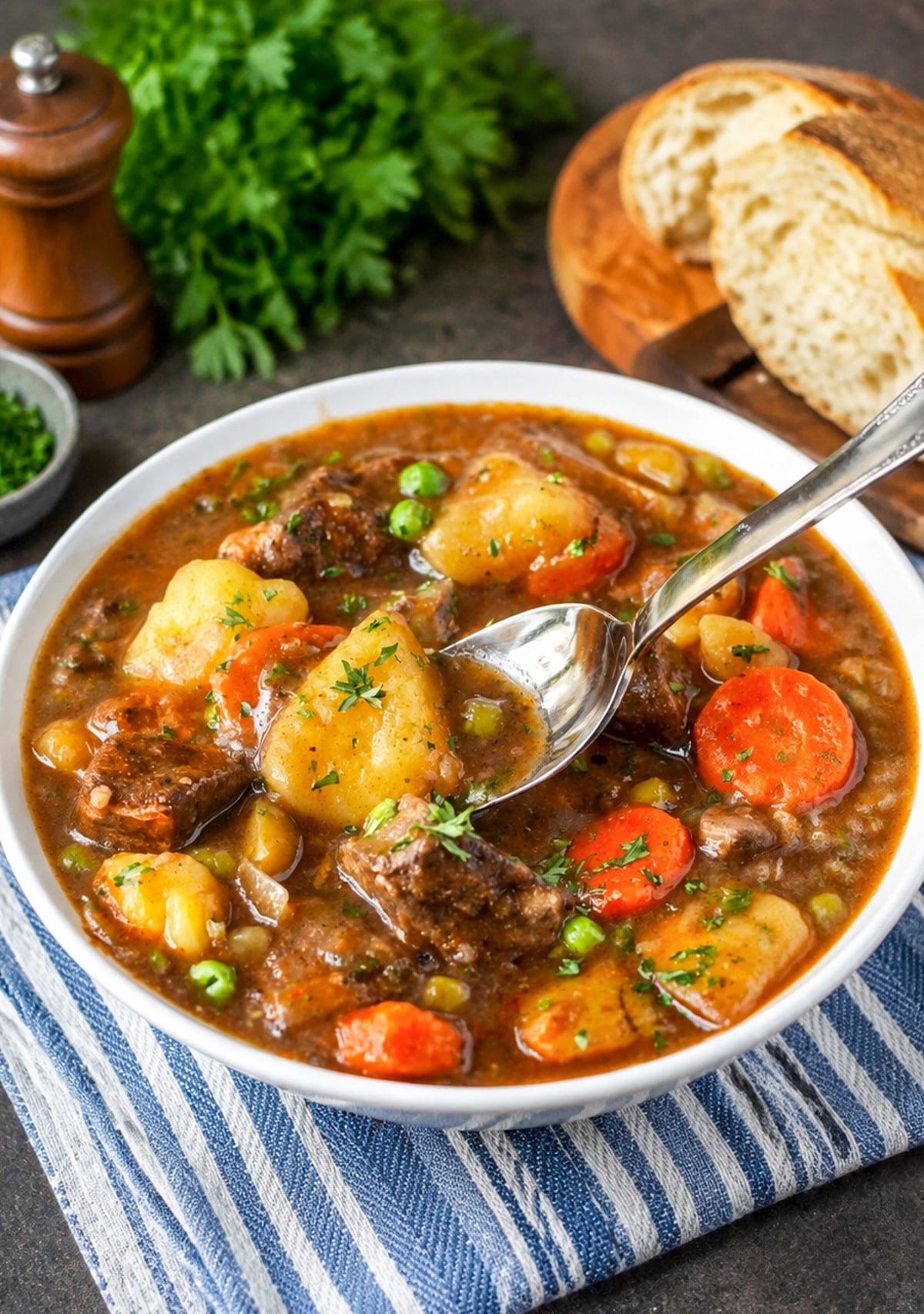 A bowl of beef stew with a spoon scooping up a bite.
