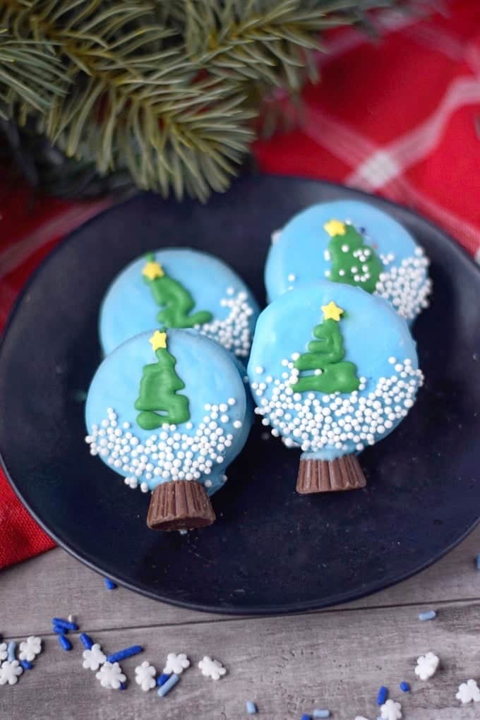 Four oreo dipped cookies decorated as snow globes.