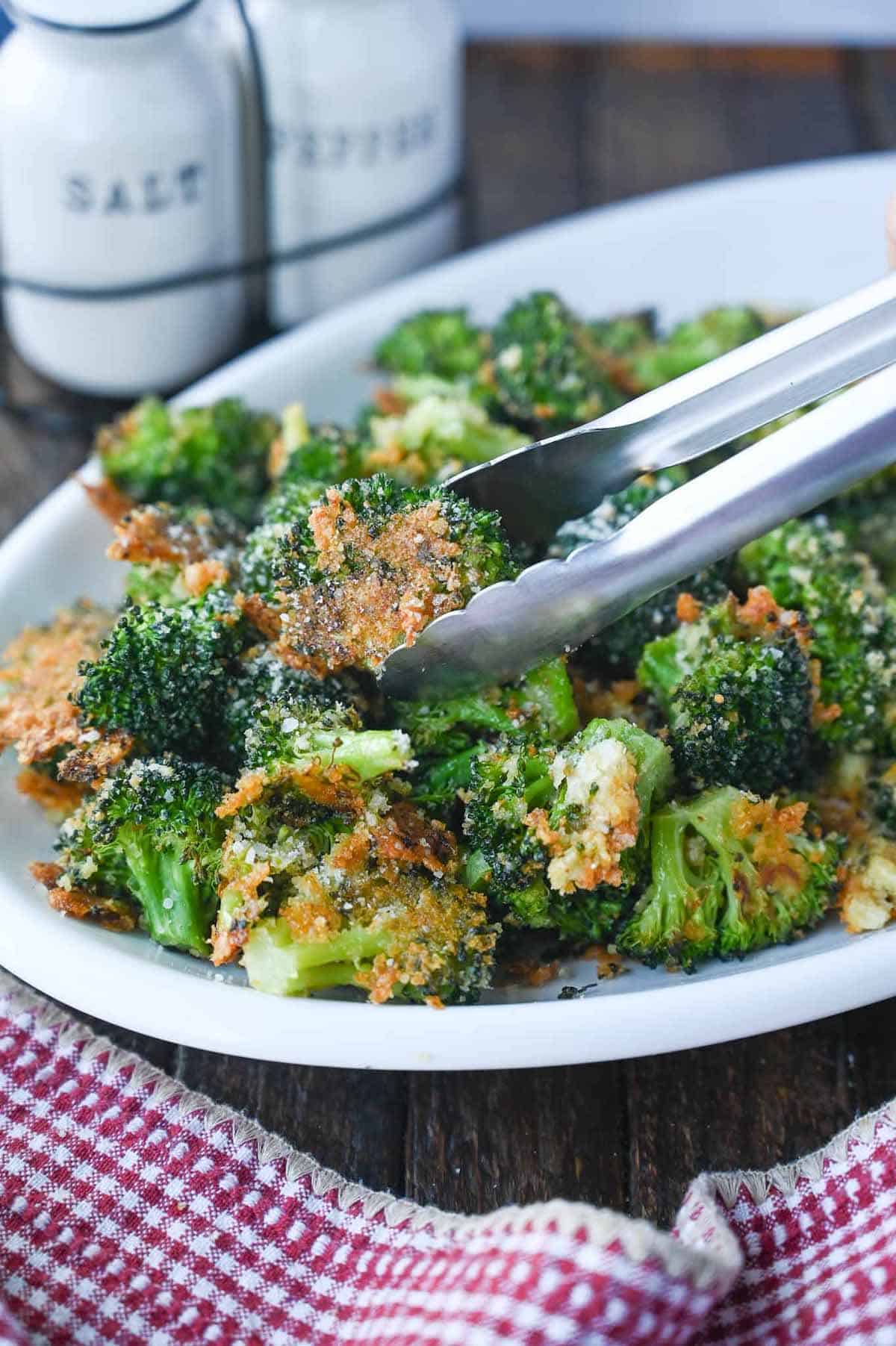 Roasted broccoli on a white platter.