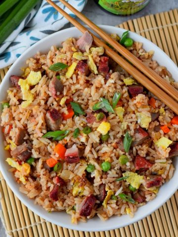 pork fried rice in a white bowl with chopsticks