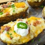 Bacon jalapeno twice baked potato on a baking sheet with sour cream on top pinterest pin.