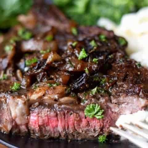 A close up of a plate of food, with Rib eye steak