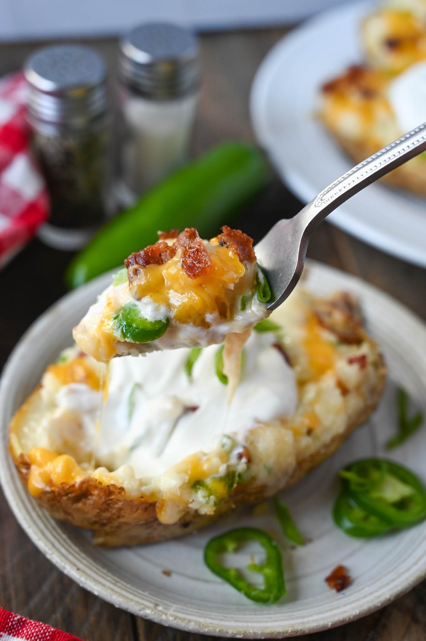 A fork taking a bite of twice baked potato.