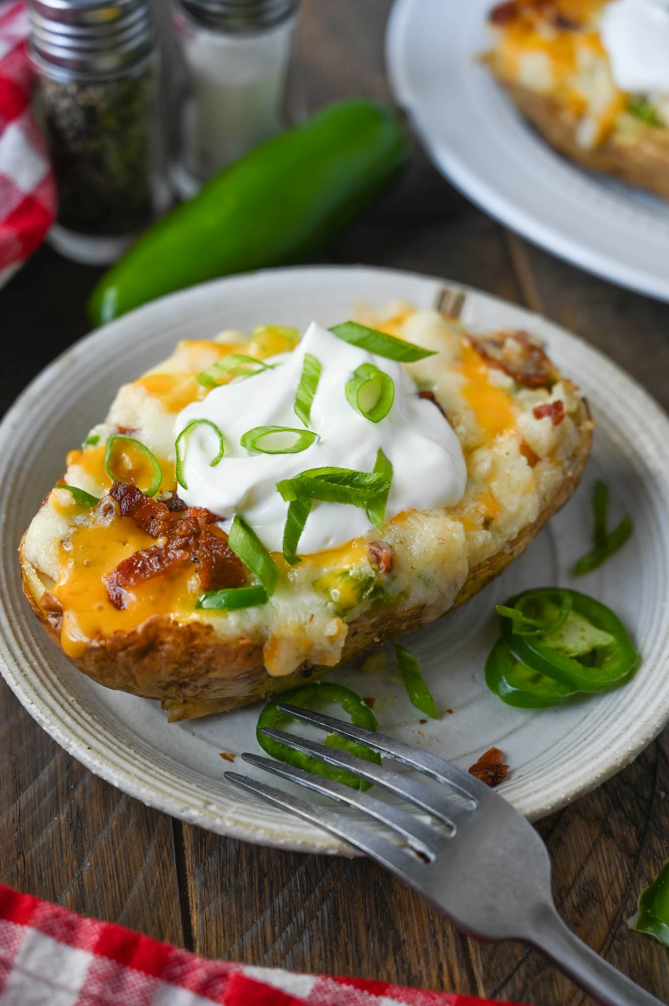 Bacon jalapeno twice baked potato on a plate with a fork.