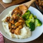 Honey butter garlic chicken on top of mashed potatoes with broccoli.