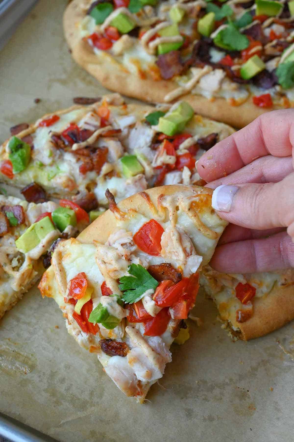 A piece of flatbread being picked up.