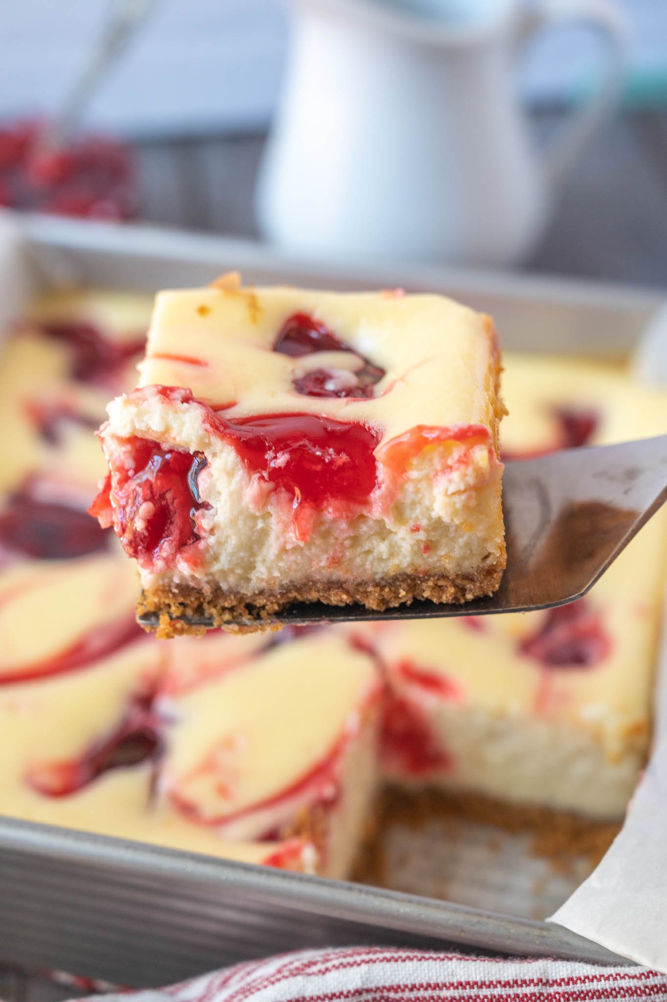 A spatula picking up a cheesecake bar.