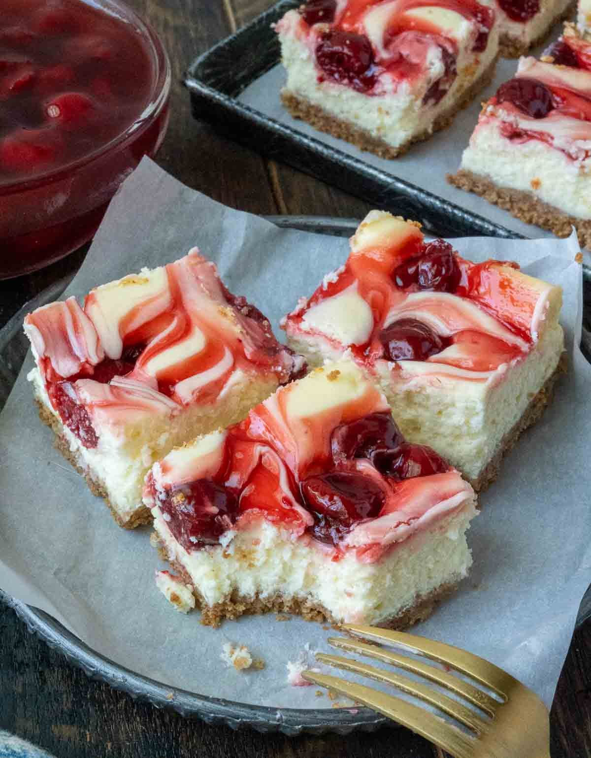 Cherry cheesecake bars on a plate.