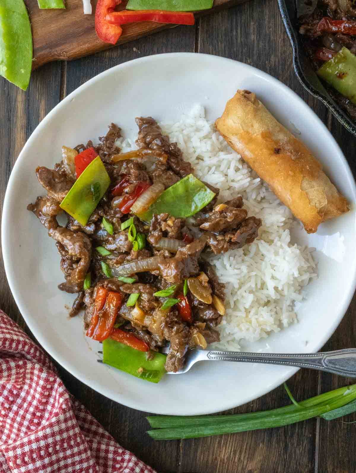 Beef stir fry on top of white rice.
