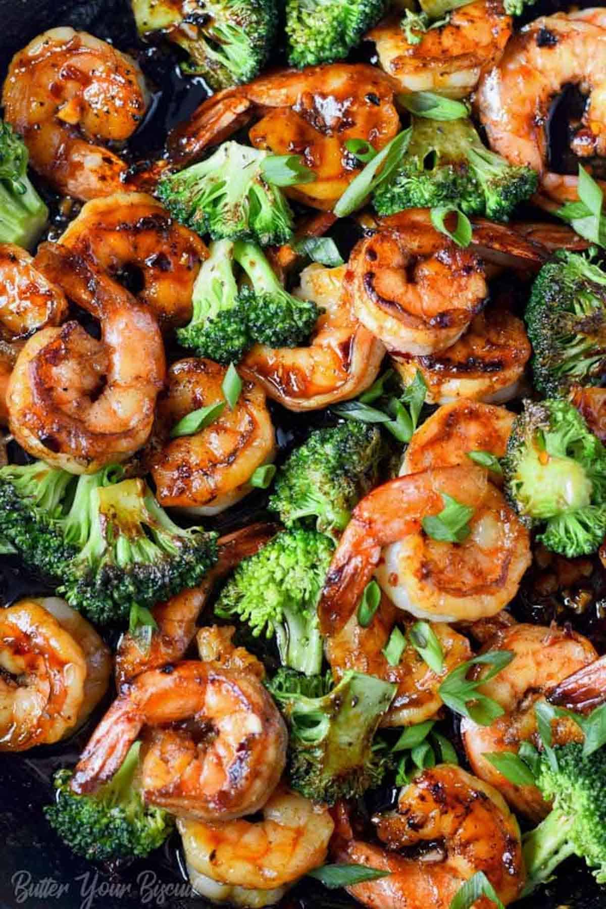 A platter with honey garlic shrimp and broccoli on it.