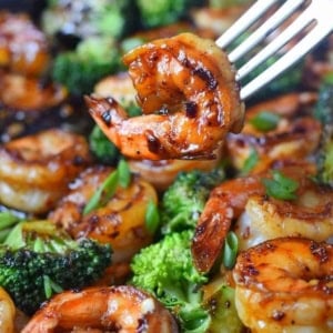 A fork picking up a honey garlic shrimp.