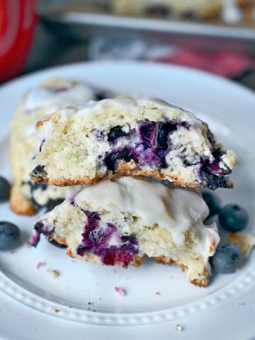 Lemon blueberry scone broken in half and stacked on top of each other.