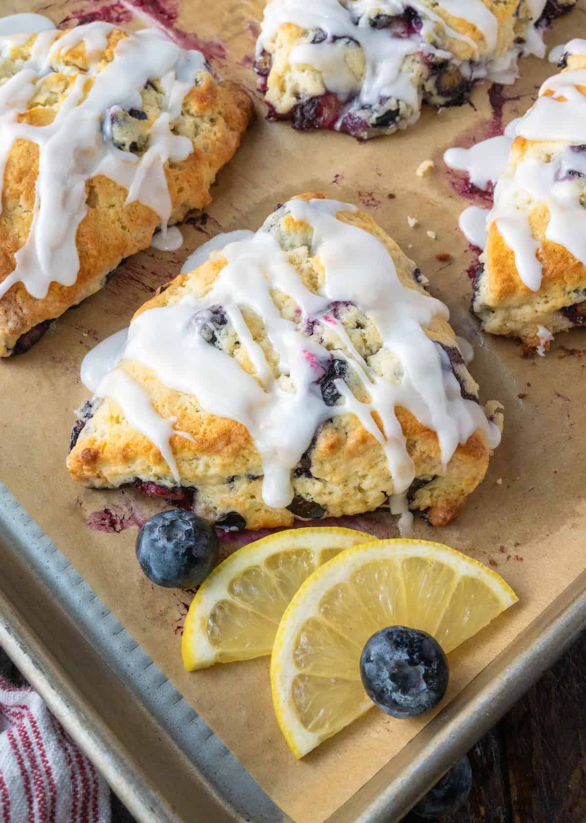 blueberry scones on a baking sheet with lemon slices.