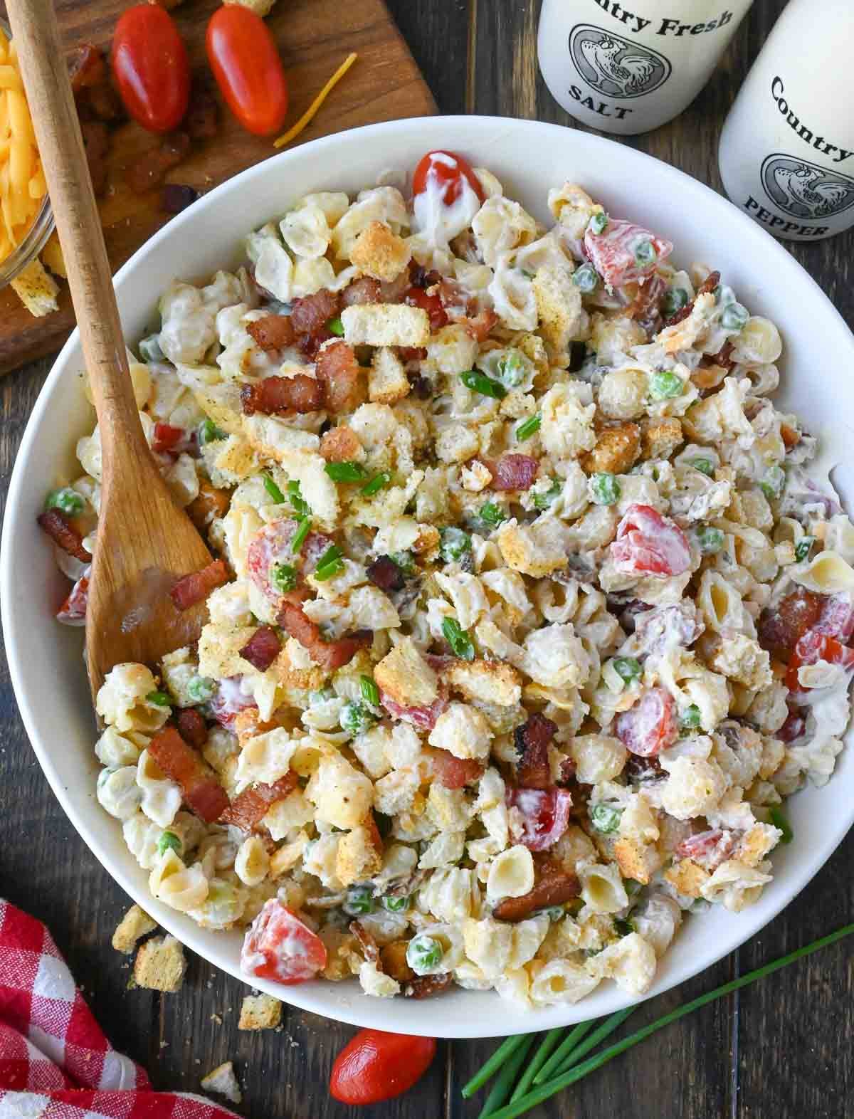 Bacon ranch pasta salad in a white serving bowl.