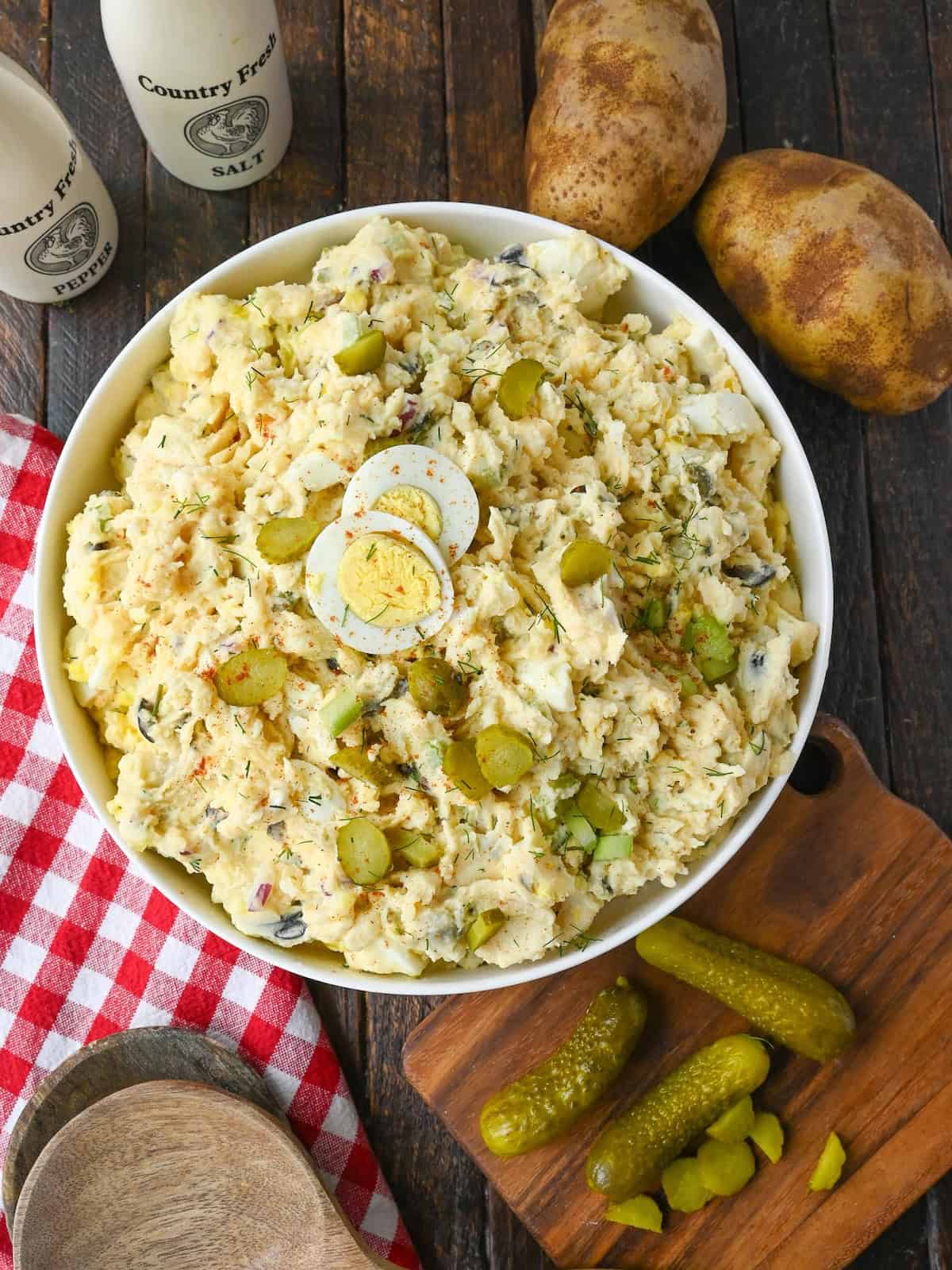 Potato salad in a bowl with chopped pickles on top.