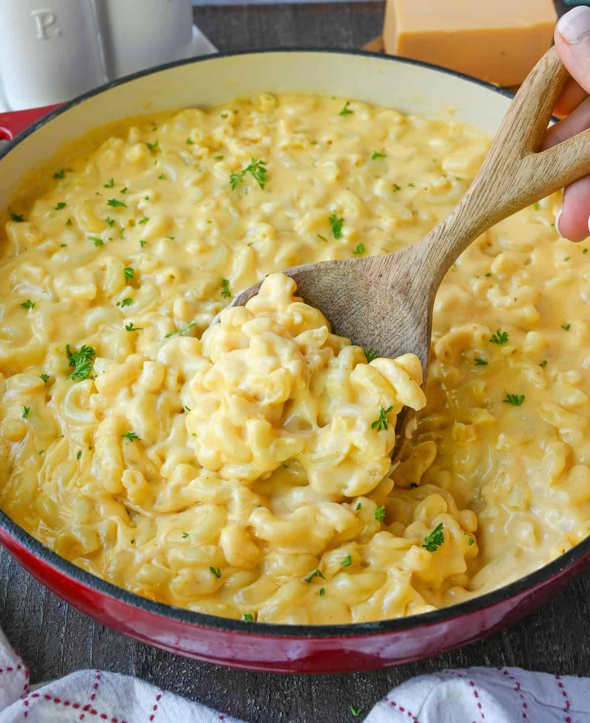 A wooden spoon scooping up some mac n cheese.