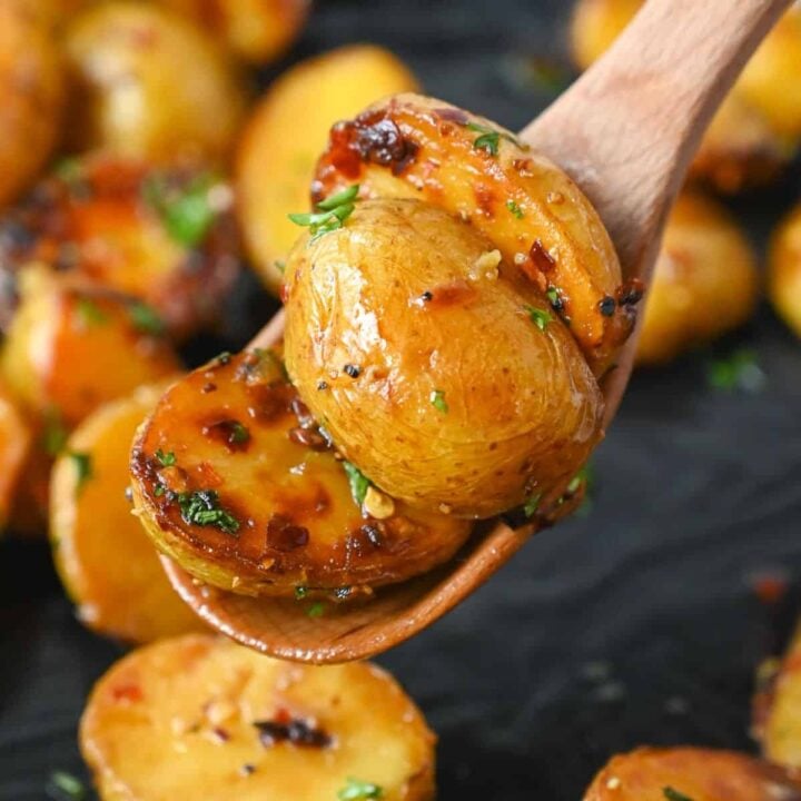 A wooden spoon scooping up potatoes