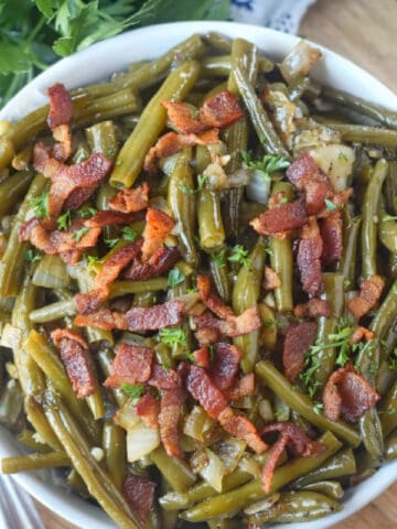 Slow cooker green beans in a white serving bowl.