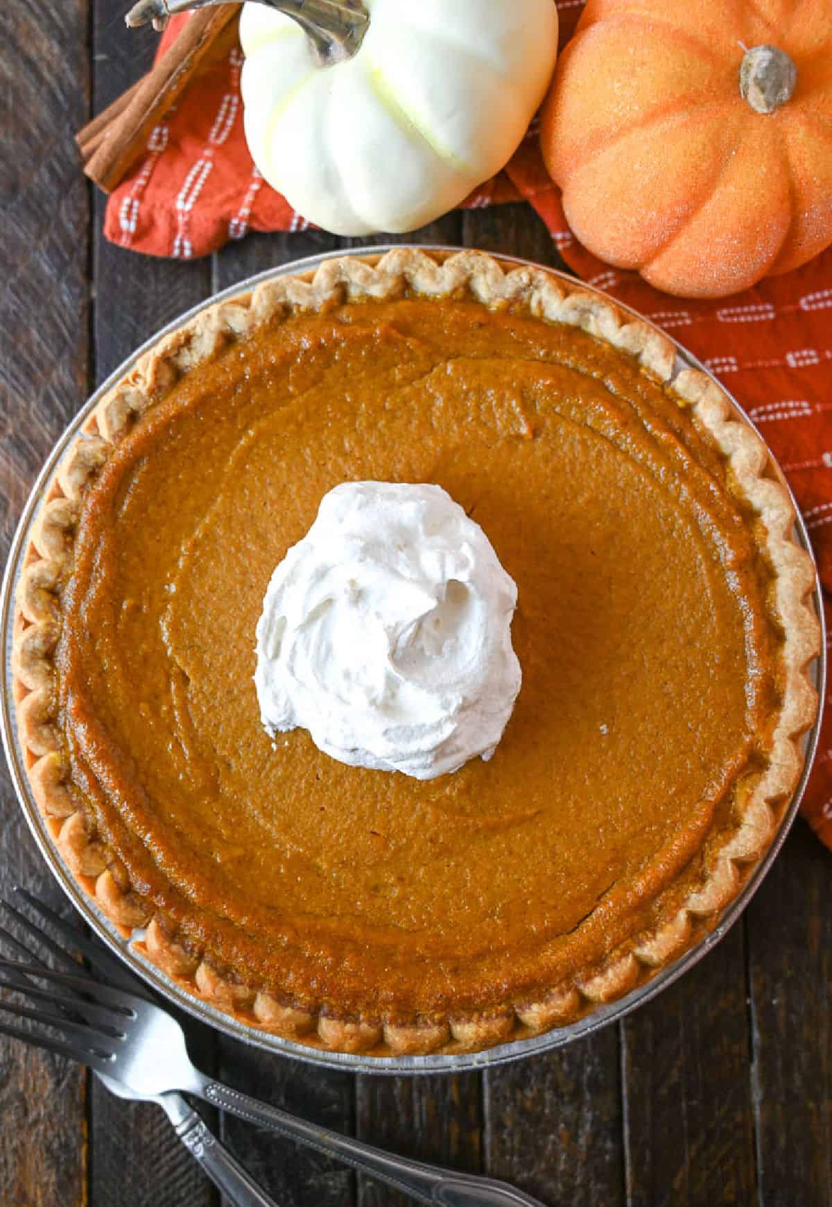 A whole buttermilk pumpkin pie with whipped cream in the center.