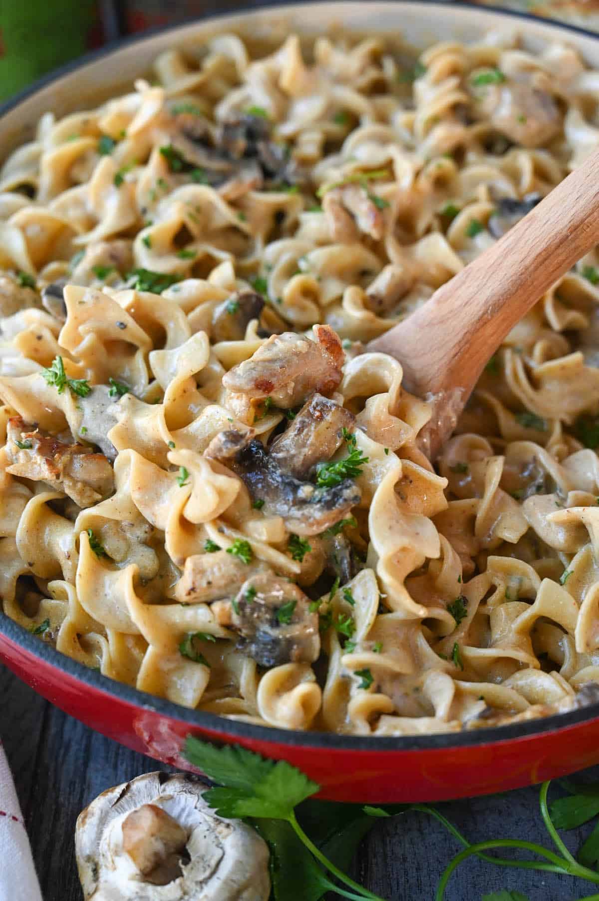 A wooden spoon scooping up a serving of stroganoff.
