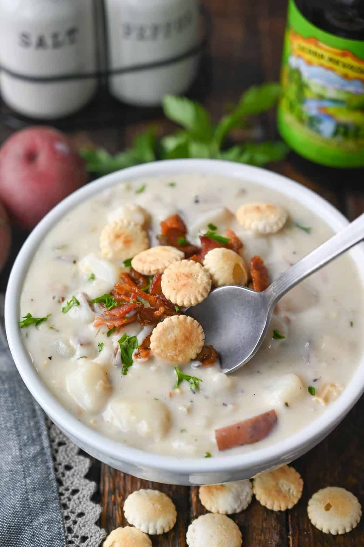 Clam chowder in a bowl with a spoon scooping some out.