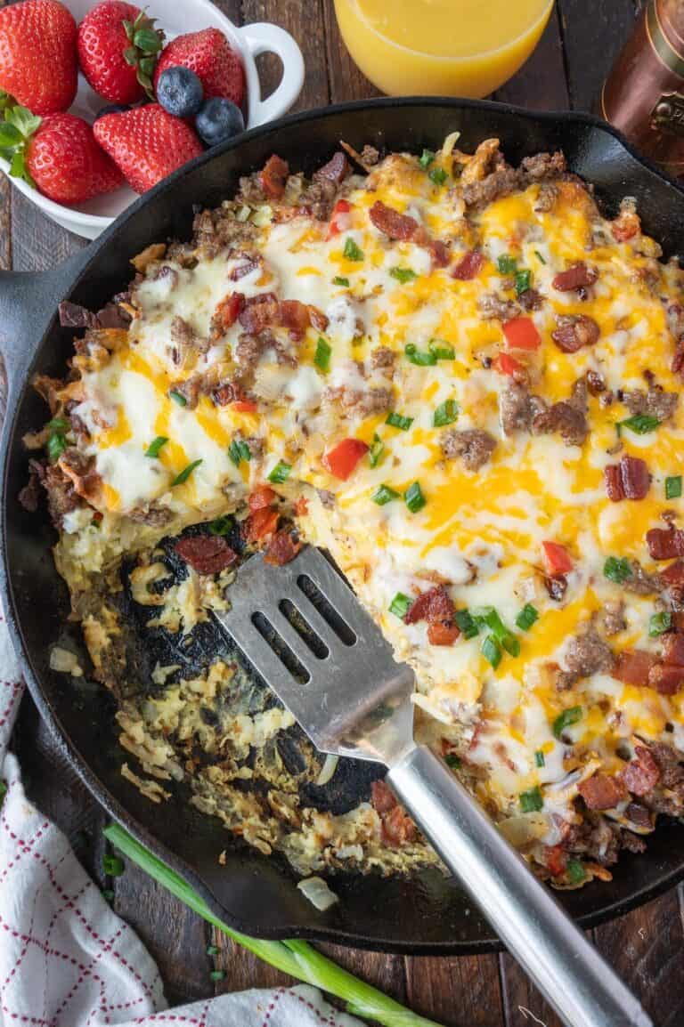 Breakfast casserole in a skillet with a spatula.