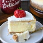 A slice of cheesecake on a white plate with a fork.