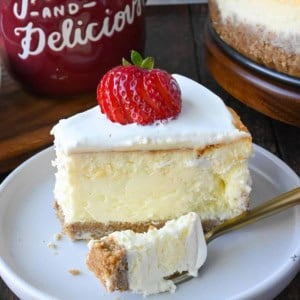 A slice of cheesecake on a white plate with a fork.