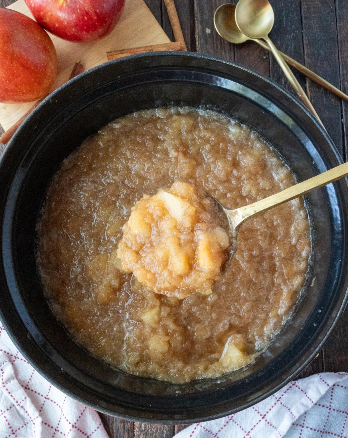 A serving spoon scooping up some homemade applesauce.