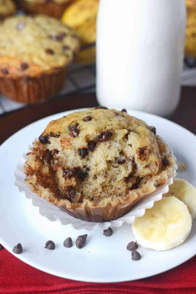 Chocolate chip banana muffin with slices of banana on a plate.