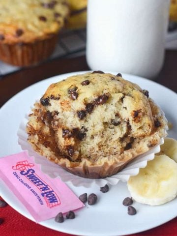 Chocolate chip banana muffin on a plate, with Sweet N Low packet.