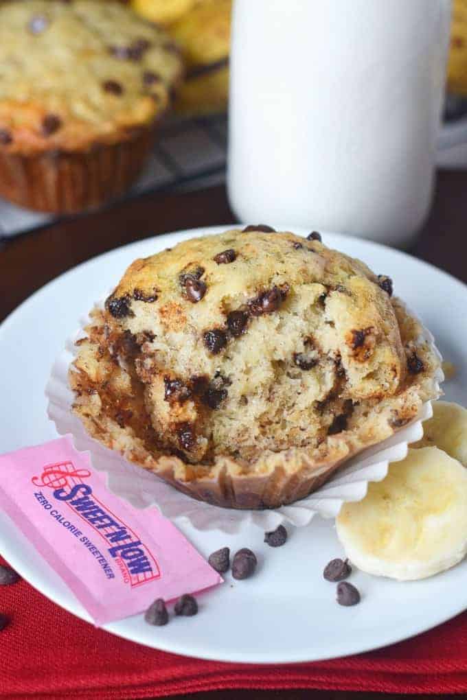 Chocolate chip banana muffin on a plate, with Sweet N Low packet.