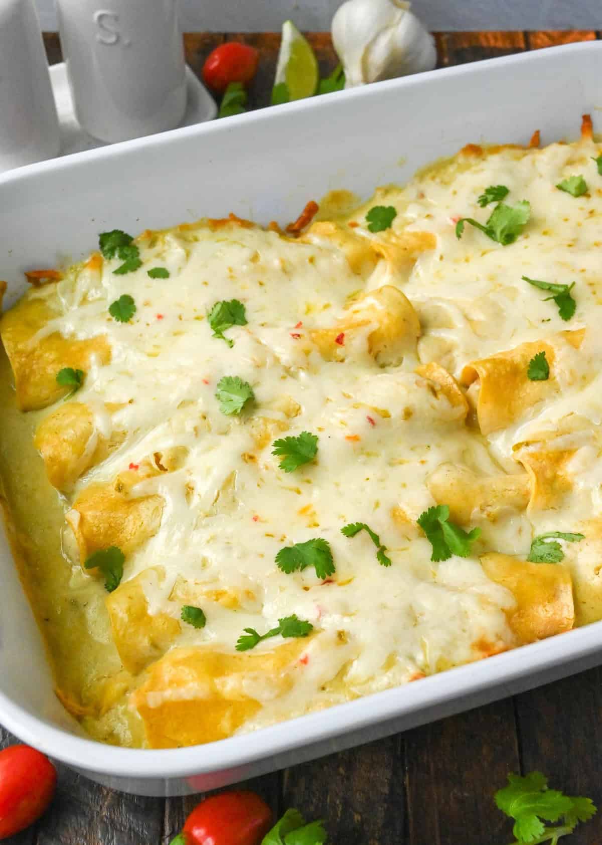 White chicken chile enchilada in a baking dish.