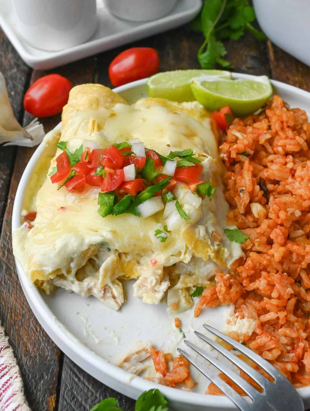 Chicken enchilada on a plate with mexican rice.