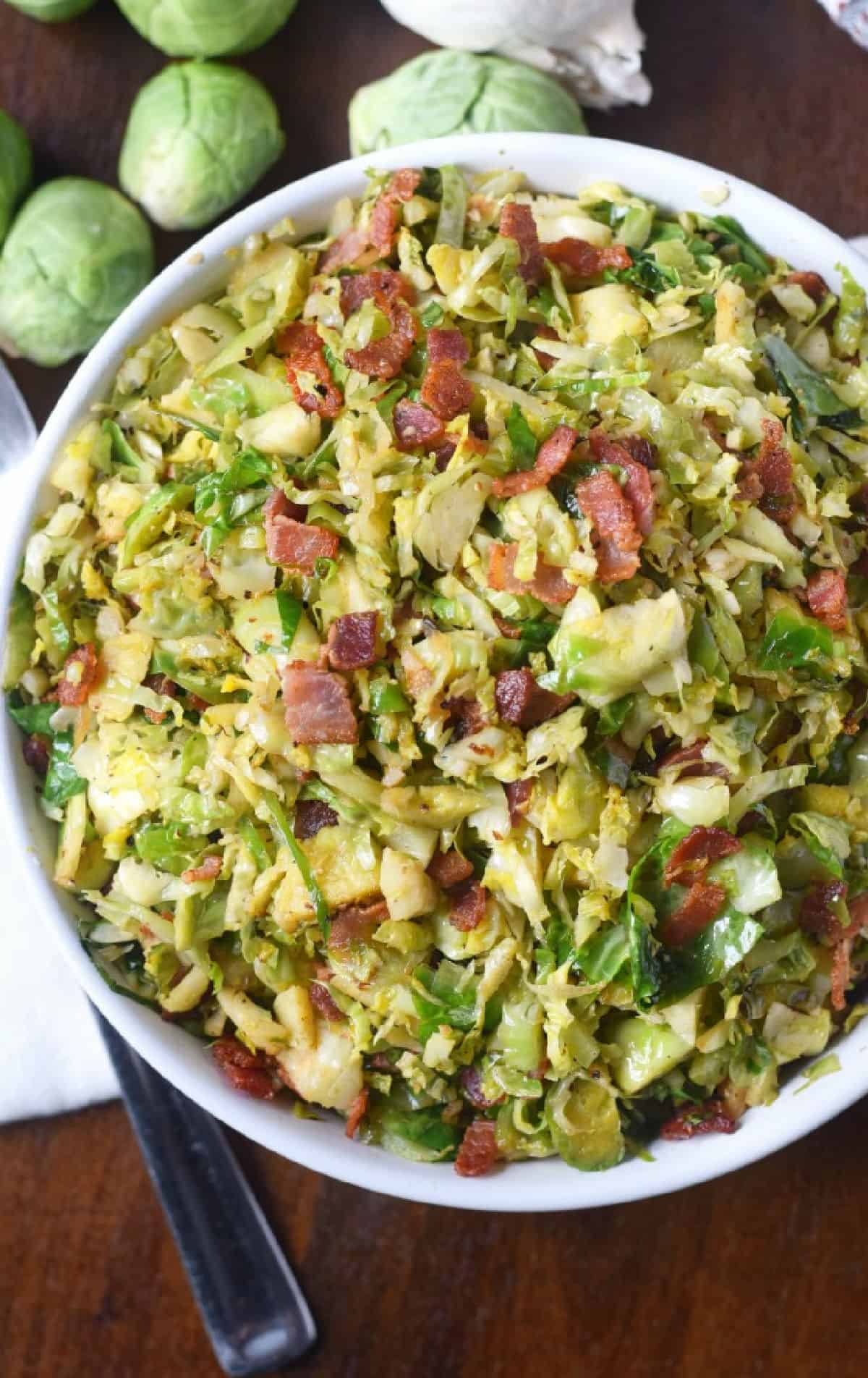 Brussels sprouts with bacon in a white bowl.