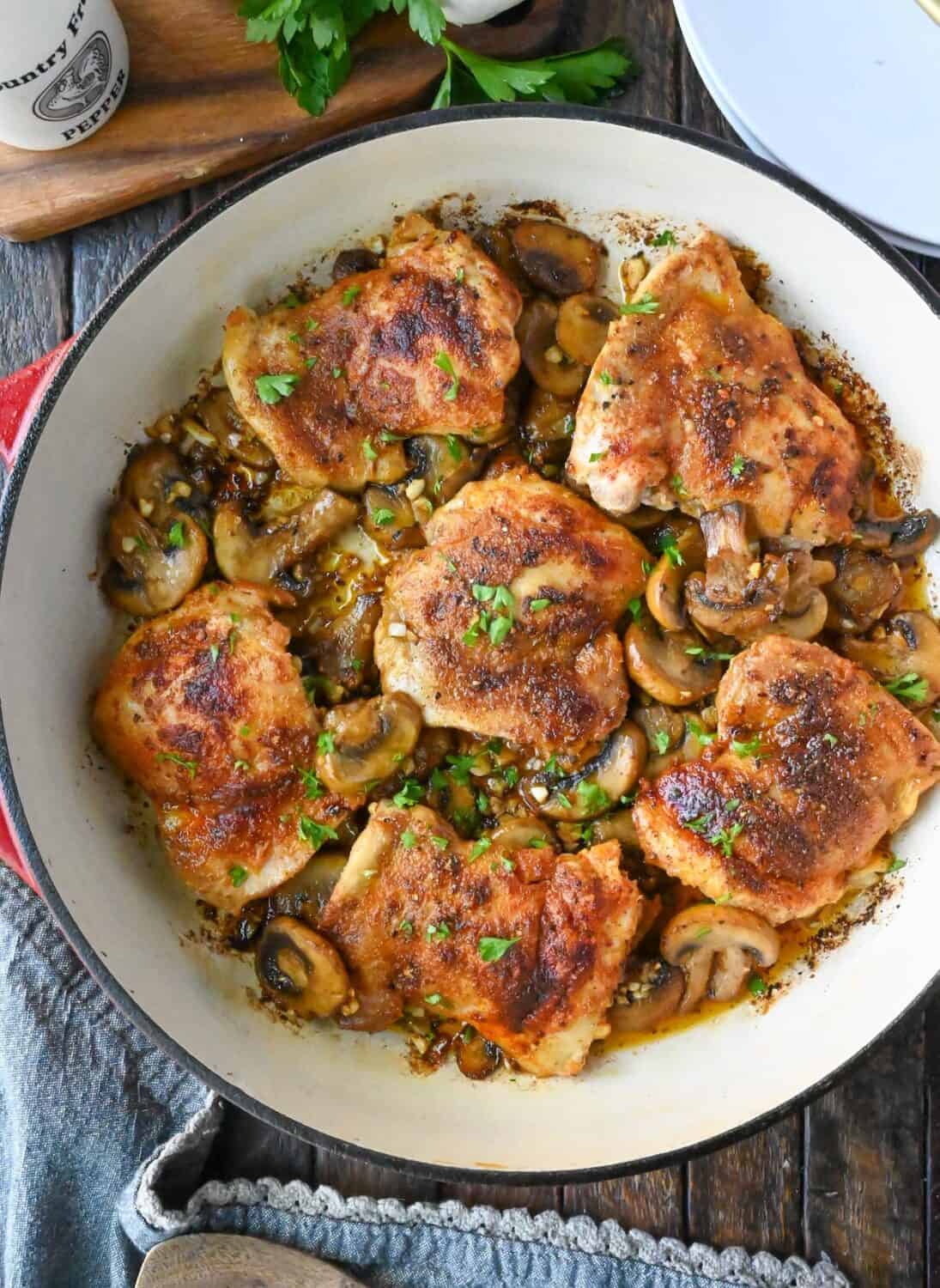 garlic mushroom chicken thighs in a skillet.