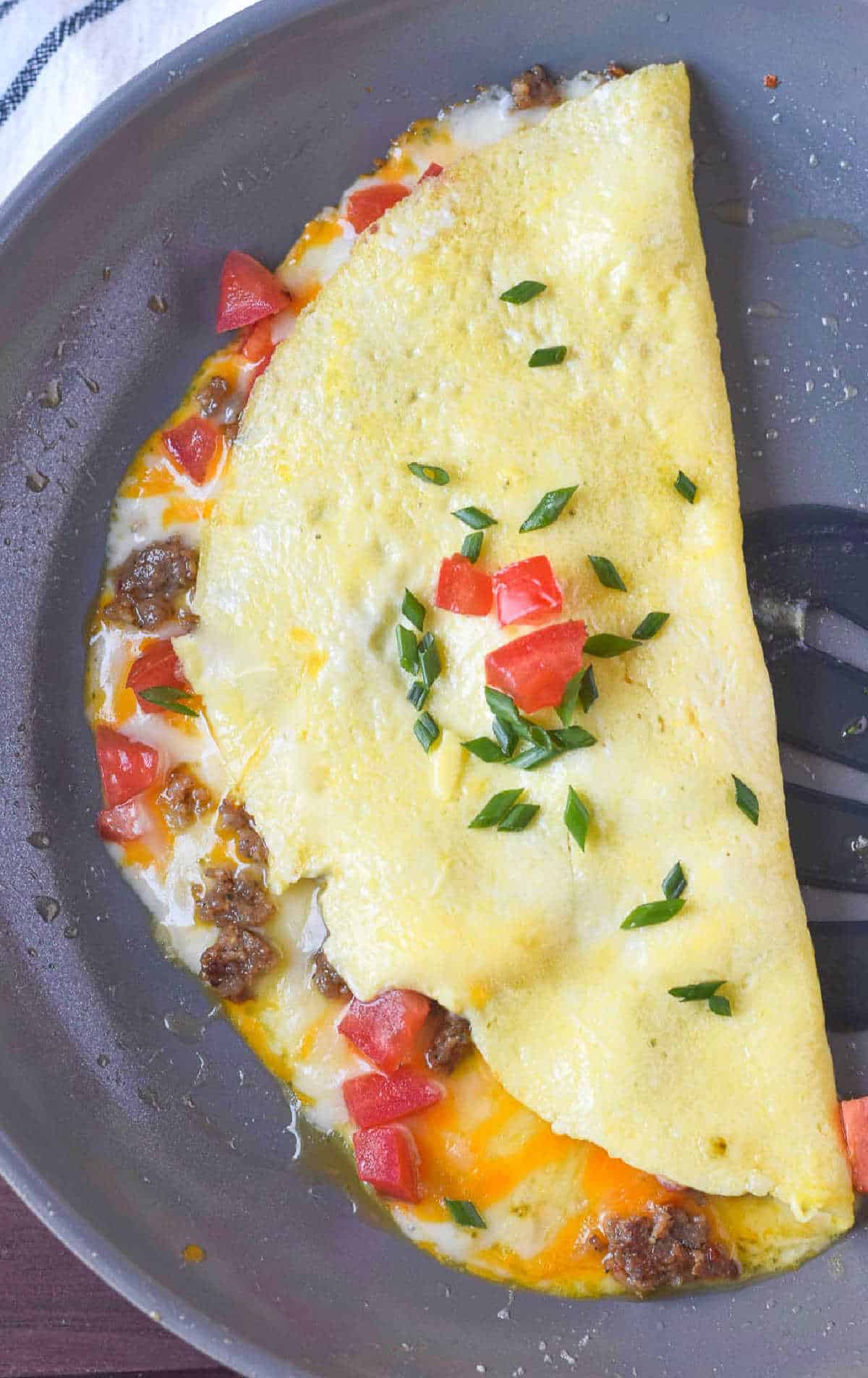 Sausage cheese omelet finished in a skillet.