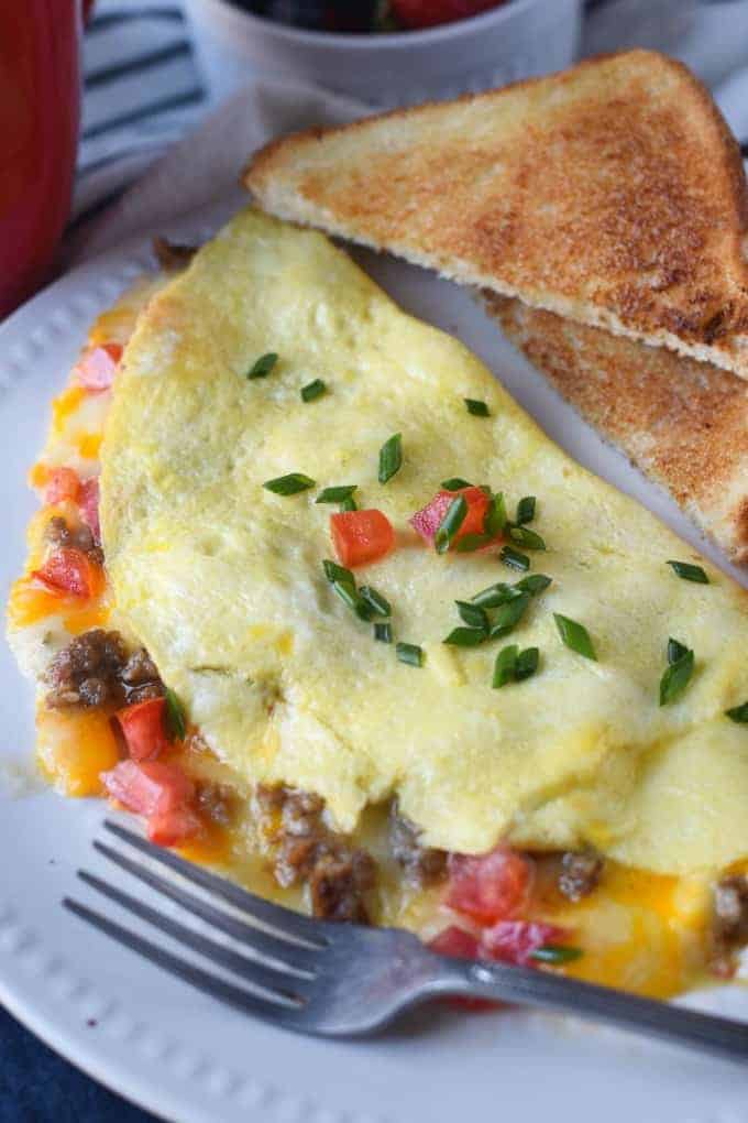 An omelet on a plate with toast.