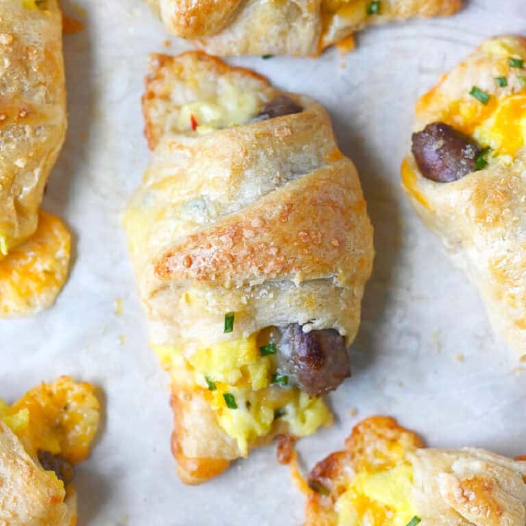 Sausage crescent rolls on a baking sheet.