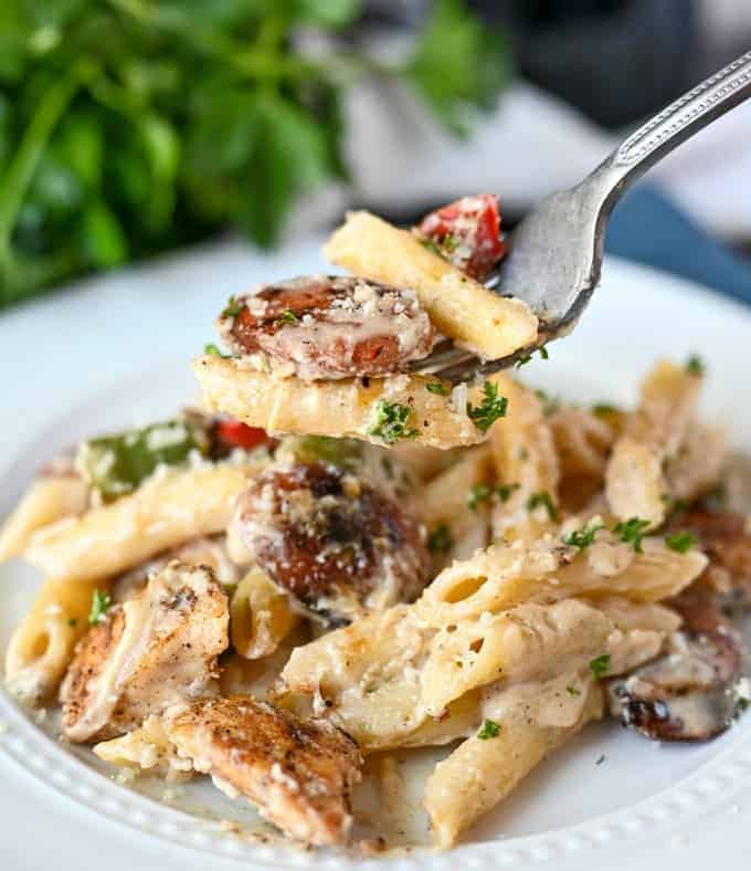 Bite of chicken and pasta on a fork.